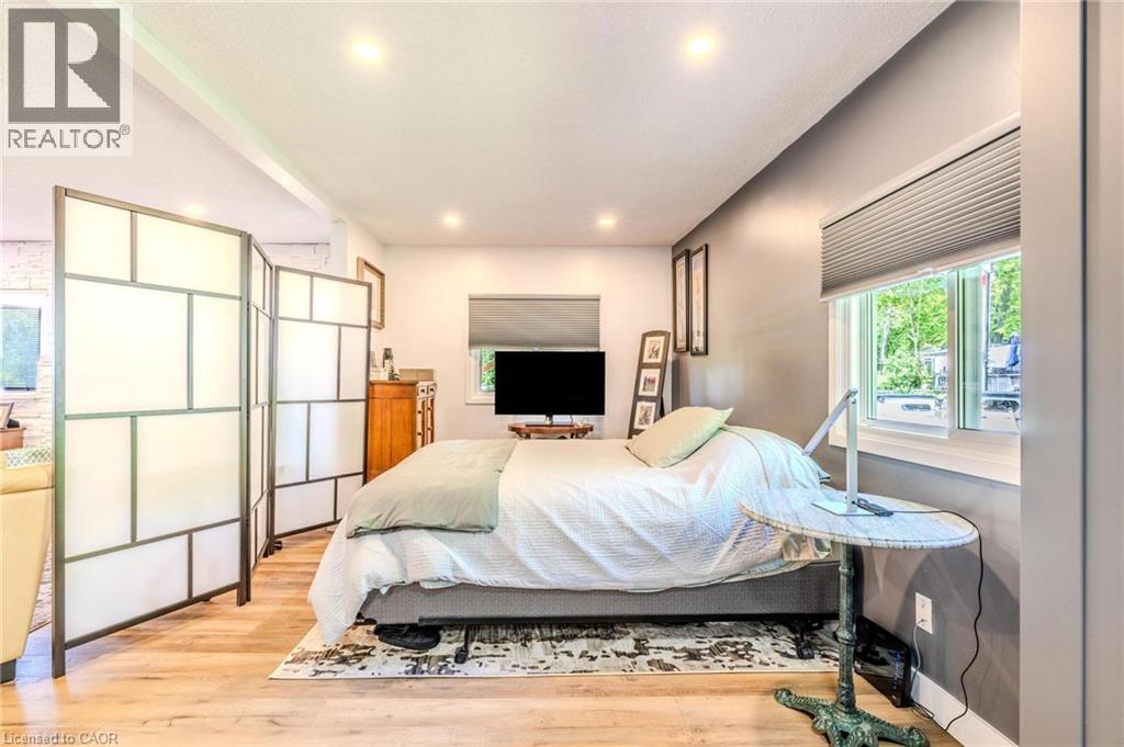 Room divider with geometric paneling, wood-finish flooring, recessed ceiling lighting, and a window with pleated blinds