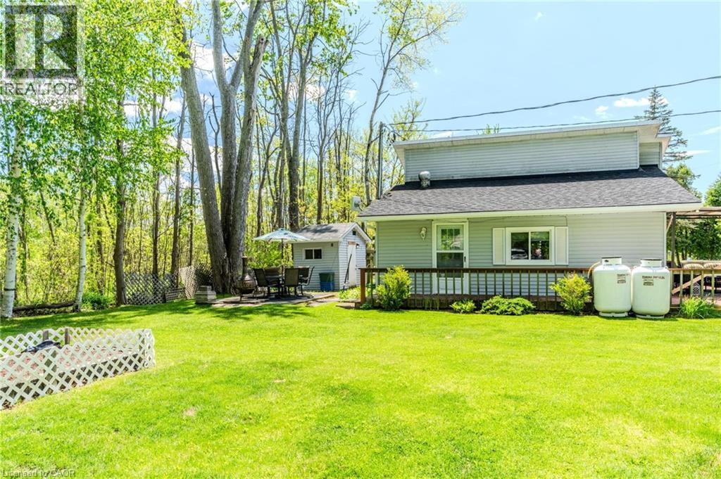 Expansive green lawn with a white lattice fence, leading to a wooden deck