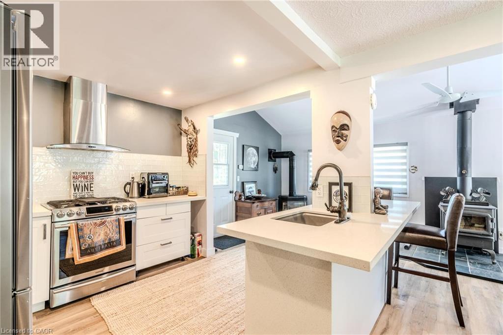 Kitchen featuring stainless steel appliances, white subway tile backsplash, and light wood-finish flooring