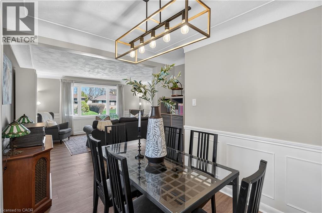Dining area featuring wainscoting and a linear brass-finish chandelier