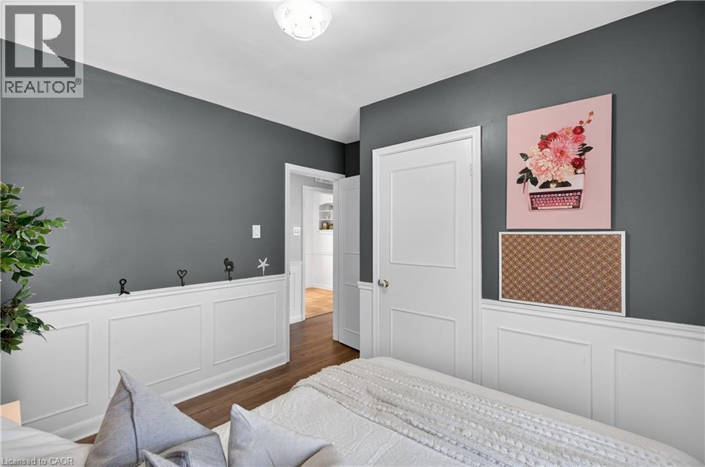 Bedroom featuring a white paneled wainscoting and a dark gray wall