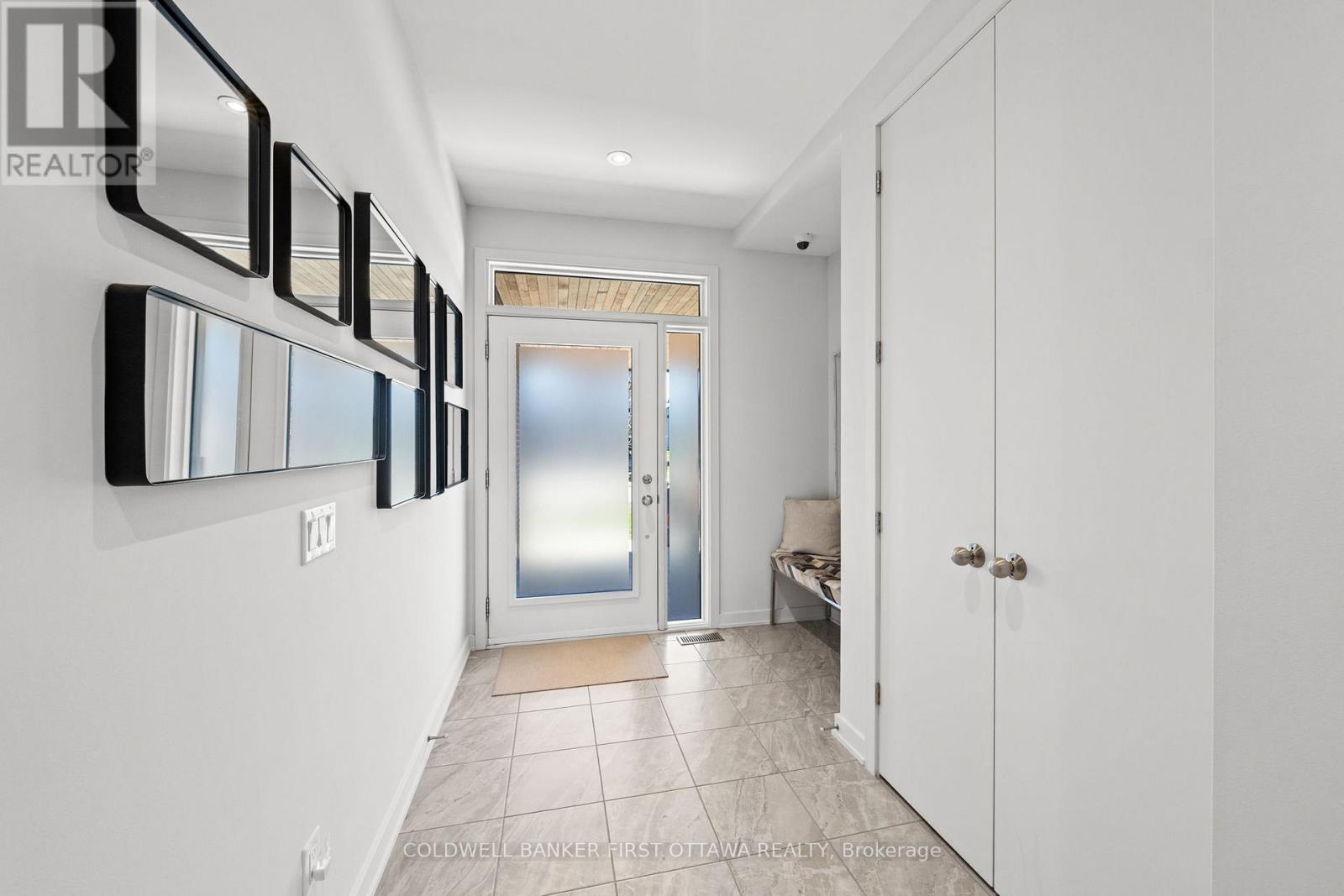 Ceramic tiled front foyer w bench space.
