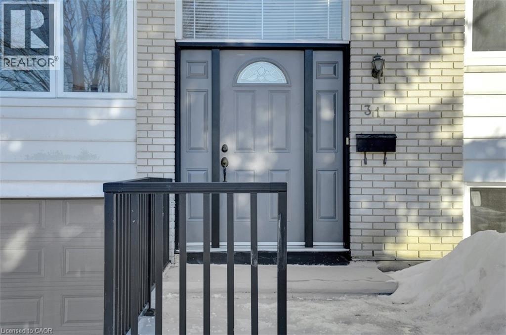Front entry featuring a panel door with an arched glass insert, sidelights, and a transom window