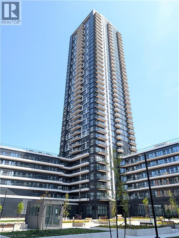 Contemporary high-rise building featuring a sleek dark facade and a multitude of private balconies