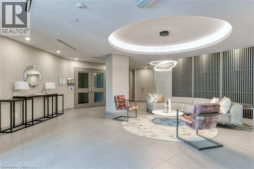 Lobby reception area featuring light gray walls, large format tile flooring, and a recessed circular ceiling detail with cove lighting