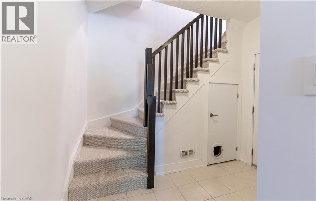 Carpeted staircase with dark wood-finish balusters and handrail