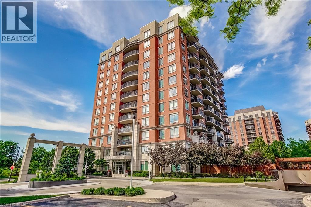 Contemporary high-rise building featuring brick and stone cladding, multiple private balconies with glass railings, and a prominent arched entrance canopy