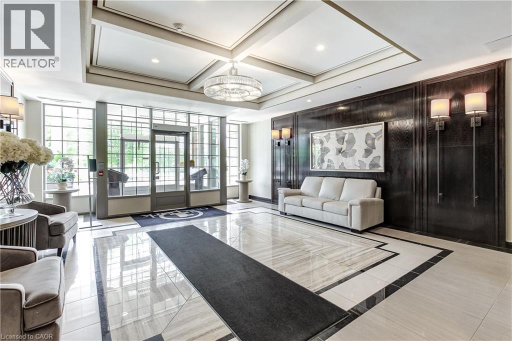 Spacious lobby featuring a coffered ceiling, recessed lighting, and a large central chandelier