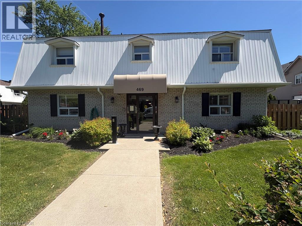 Property exterior featuring white vertical siding, light-colored brick, and black louvered shutters