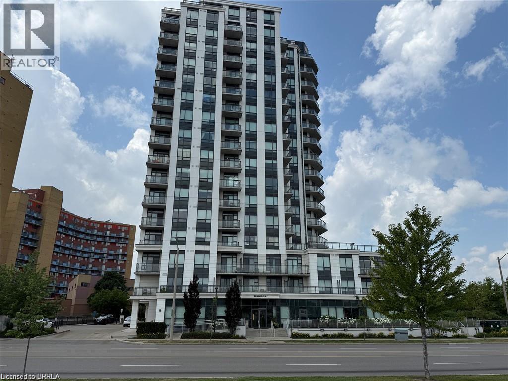 Contemporary high-rise building featuring a white facade with dark-framed windows, individual balconies with glass railings, ground-level retail spaces with expansive windows, and perimeter landscapin