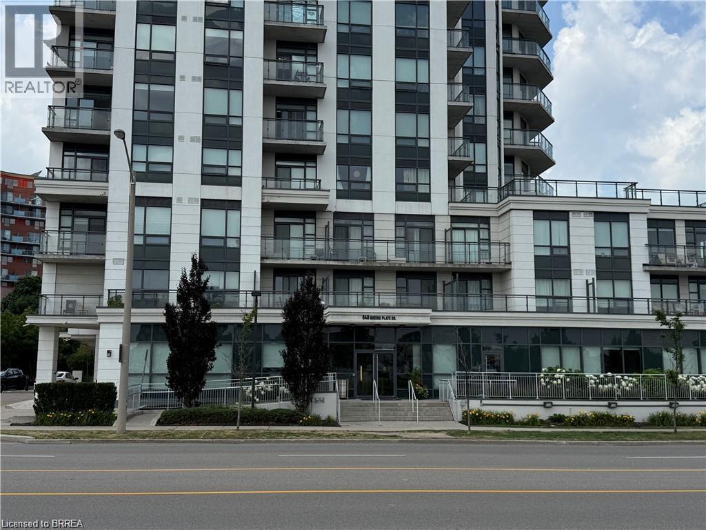 Modern high-rise residential building featuring a light-colored facade with contrasting dark-framed windows