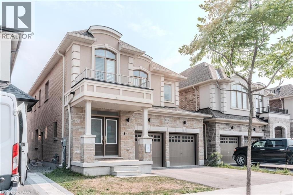 Two-story stucco and stone facade residence featuring an arched second-story window, a covered portico entry with columns, and a double-door entrance