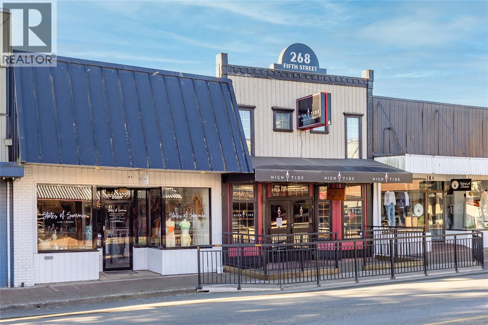 Commercial storefront featuring large display windows and a black awning