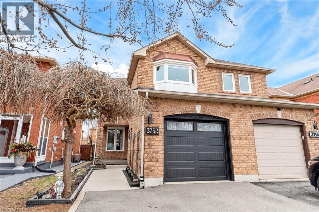 Brick exterior residence featuring an arched entryway, a bay window, and a two-car garage