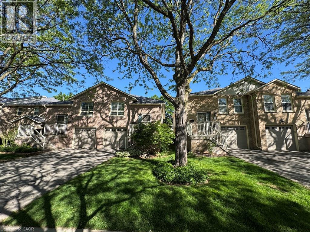 Brick exterior featuring two integrated garages, a gabled roofline, and multiple windows