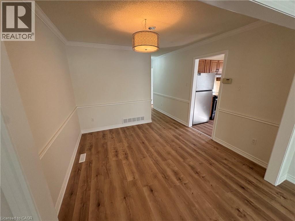 Spacious interior area featuring wood-finish flooring, white baseboards, and chair rail molding