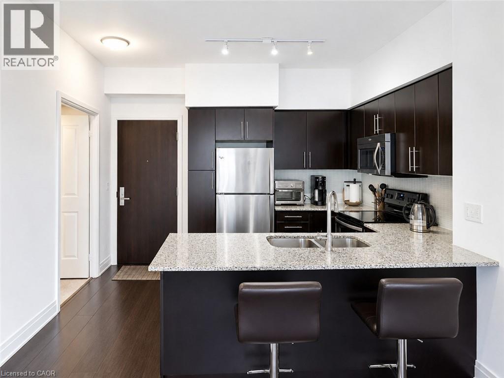 Kitchen featuring dark wood-finish cabinetry and a light-toned speckled countertop