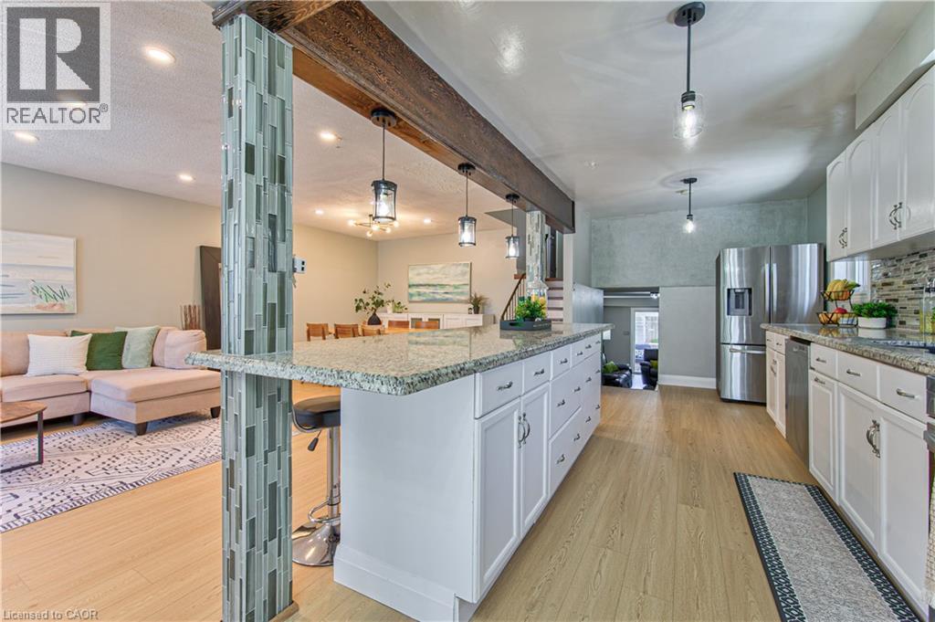 white cabinetry, stainless steel appliances, granite countertops, and a mosaic tile backsplash
