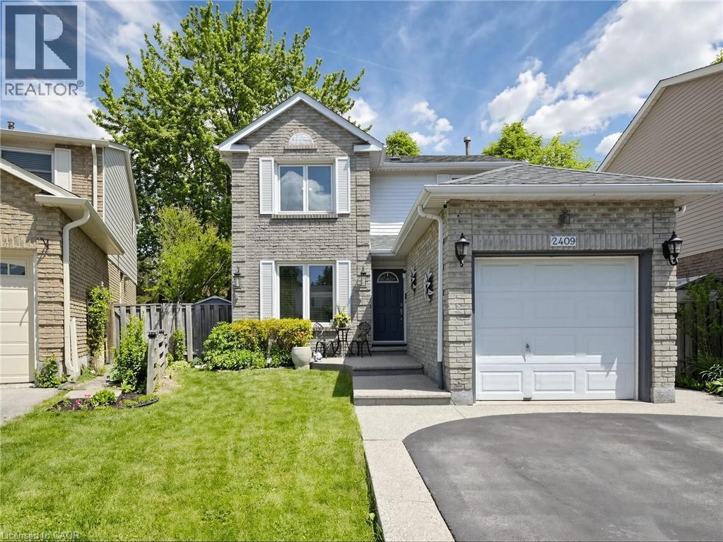 Two-story brick facade residence with a single-car garage and asphalt driveway