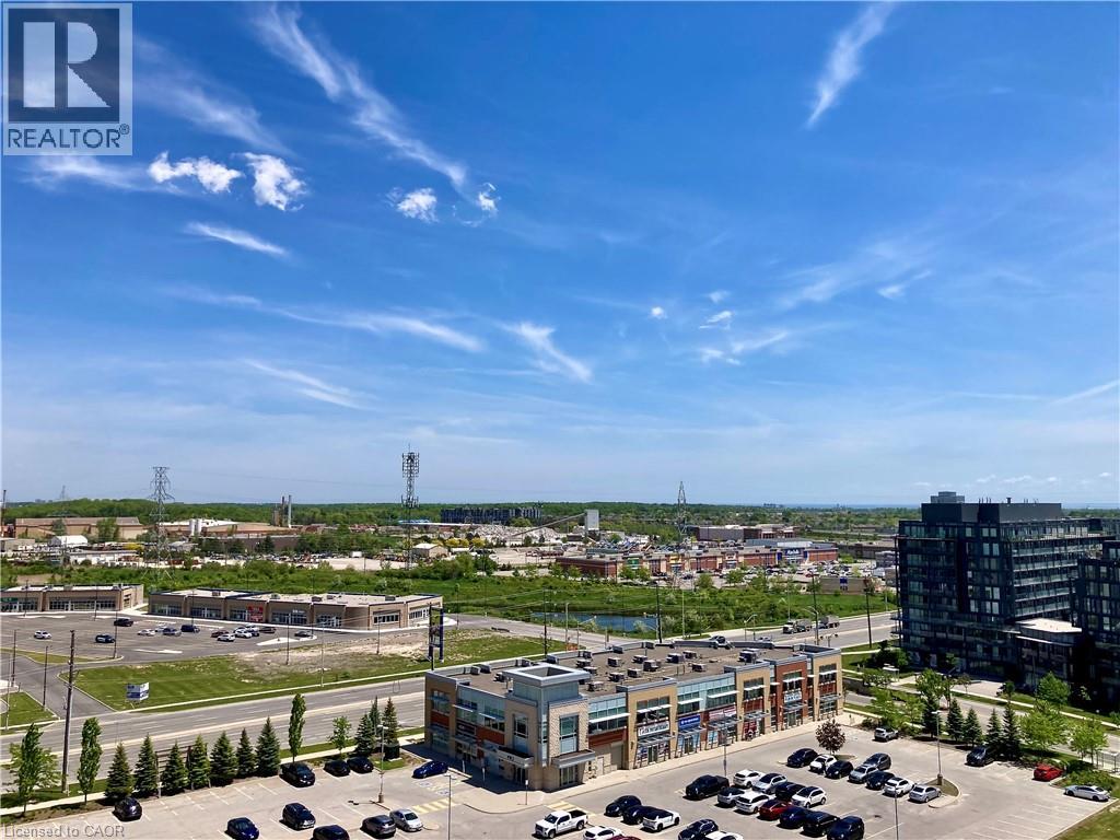 Expansive urban landscape featuring a retail plaza with multiple storefronts, a multi-story residential building, and a distant body of water