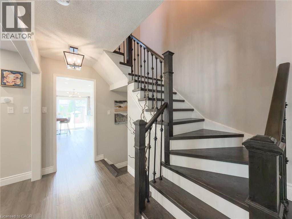 Staircase featuring dark wood-finish treads, white risers, and wrought iron balusters