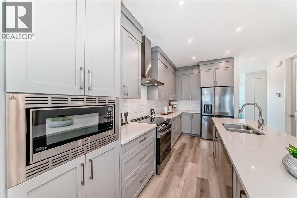 LARGE ISLAND WITH STONE QUARTZ COUNTERS,  DIMMABLE LIGHTING AND EXTERIOR EXHAUST HOOD FAN