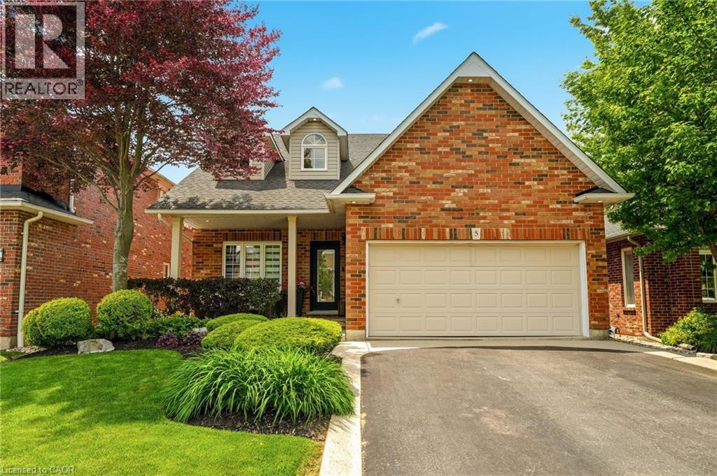 Brick exterior with an attached garage, covered front porch, and dormer window