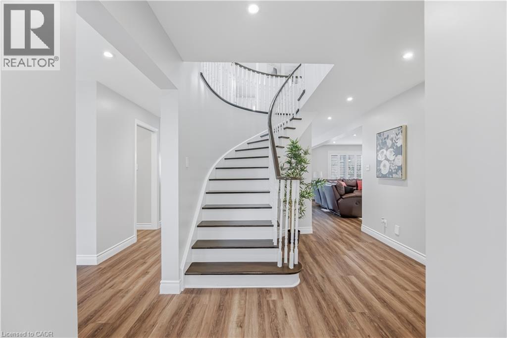 Elegant curved staircase featuring dark wood treads and a white spindle railing