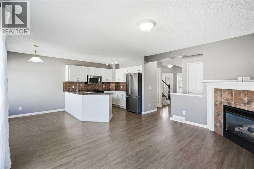 Second living space with a gas fireplace and views of the backyard and kitchen