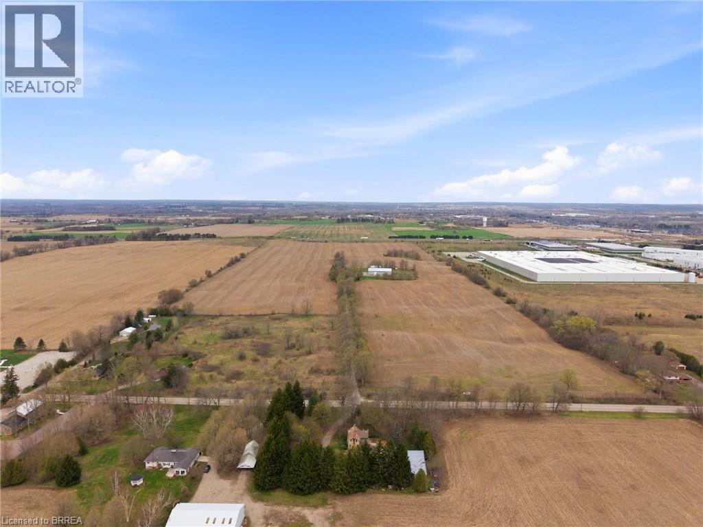 Expansive agricultural land featuring cleared fields and scattered mature trees