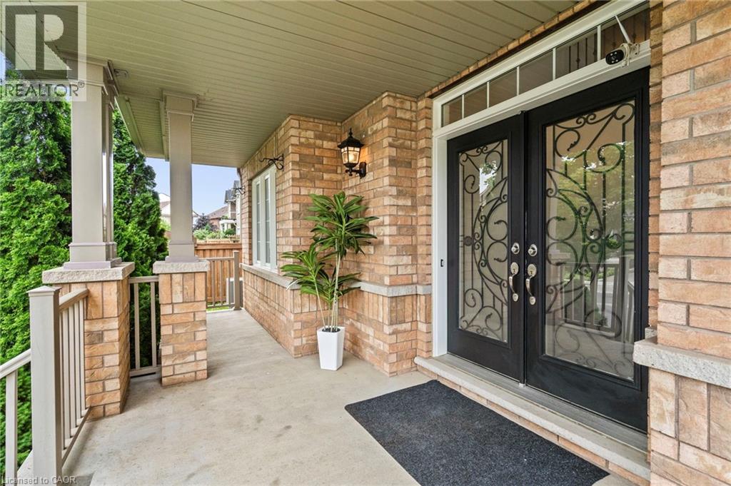 Brick facade porch featuring decorative wrought iron double entry doors