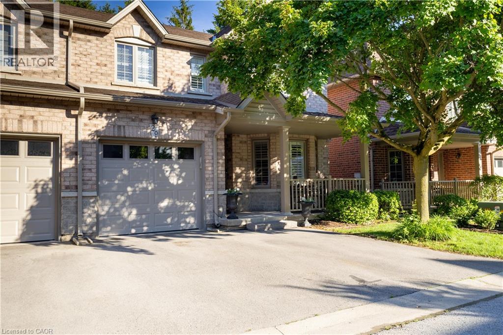 Brick and stone facade featuring a covered front porch with railing, an attached garage, and a concrete driveway
