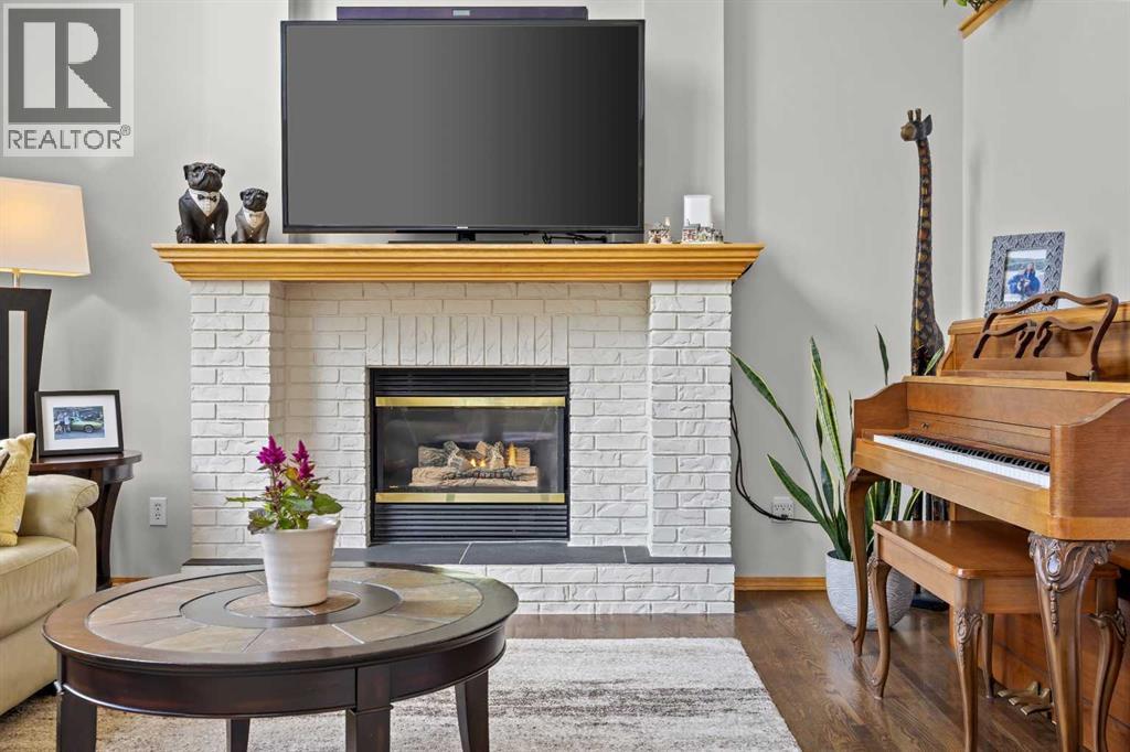 A striking white brick gas fireplace with wood mantel creates the perfect cozy focal point for relaxing evenings