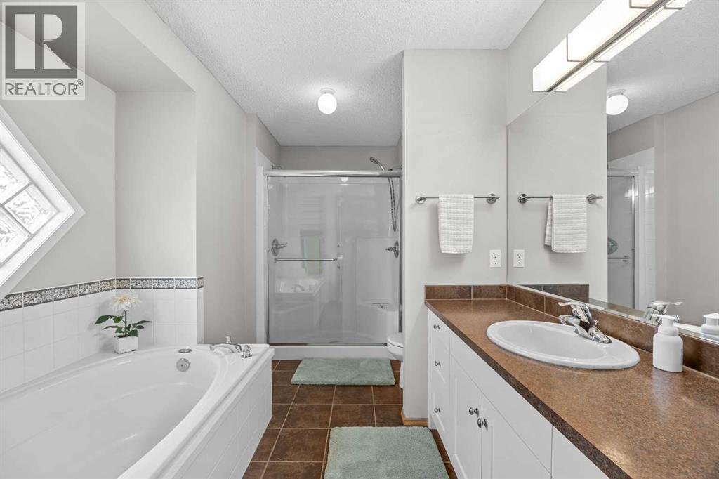 A luxurious 5-piece ensuite with a soaker tub, separate glass shower, dual storage, and a private water closet