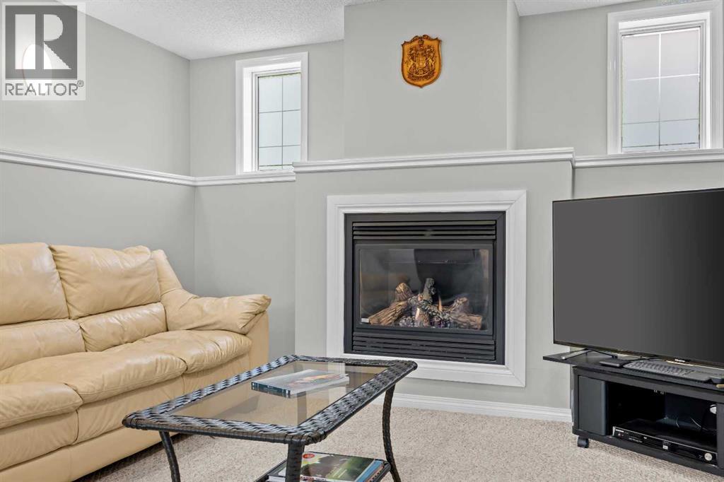 Warm and inviting, the lower-level fireplace with custom crown moulding adds comfort and character to the space