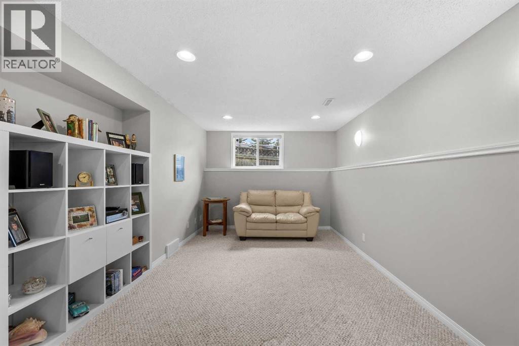 A versatile games and media room with built-in storage and large windows, ready for play, hobbies, or a home theatre setup