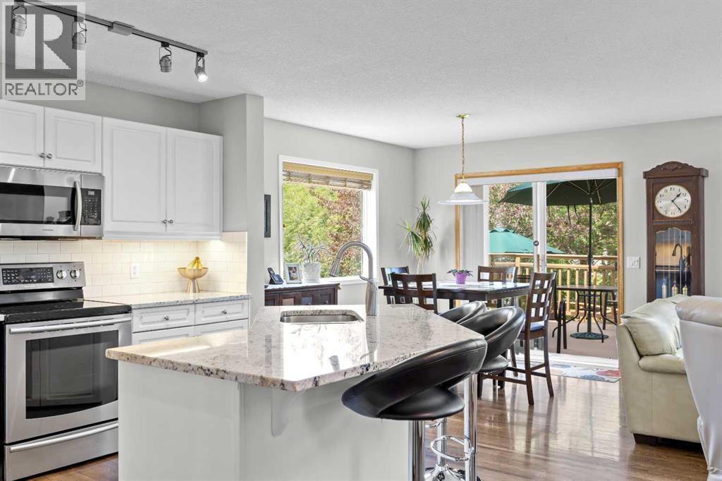 Upgraded track lighting and gleaming hardwood lead to the dining nook and walk-out deck, blending indoor comfort with outdoor living