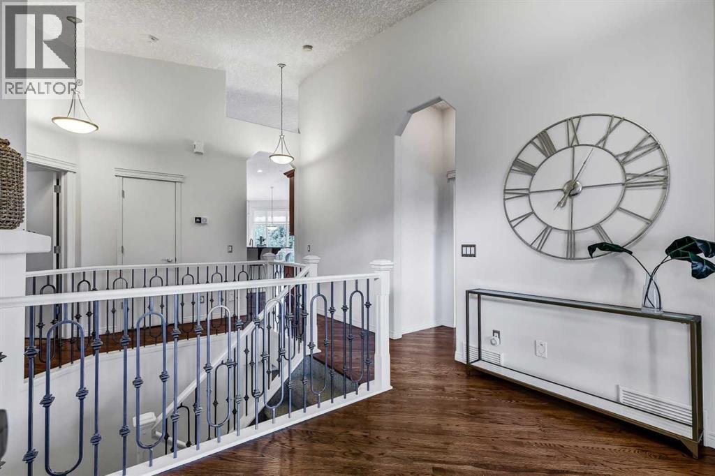 Spacious foyer with wrought iron railing and a staircase leading to the lower level