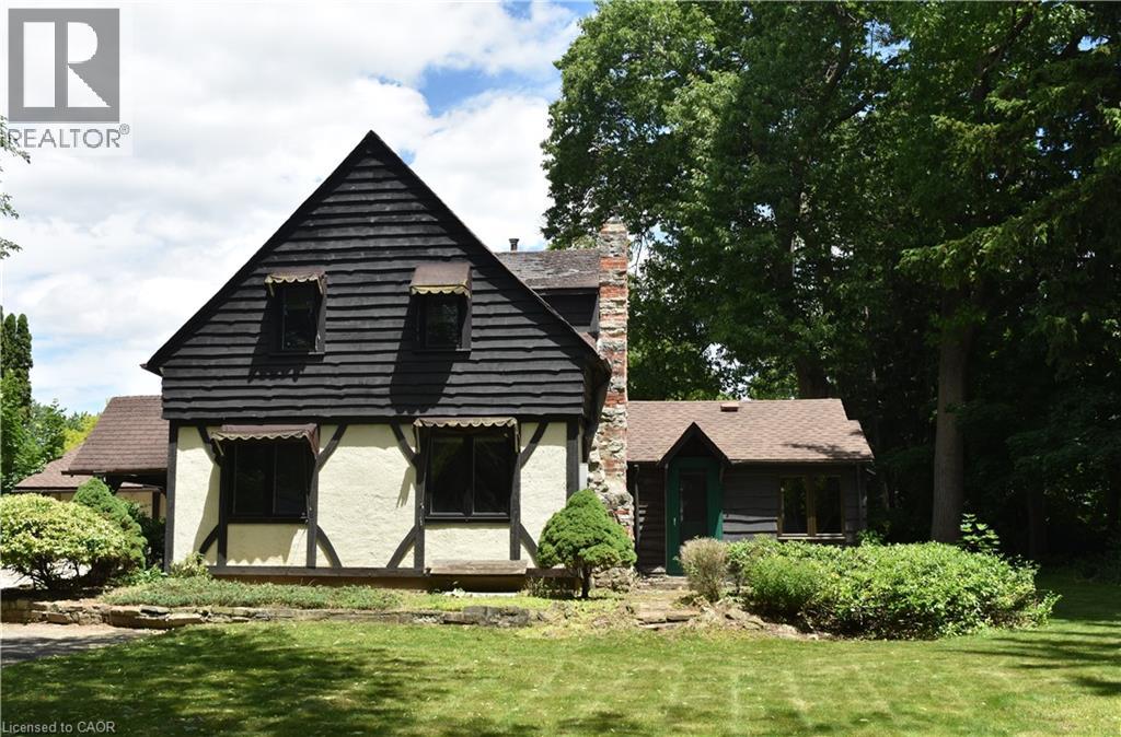 Tudor-style exterior with dark shake siding and light stucco, featuring dark trim work