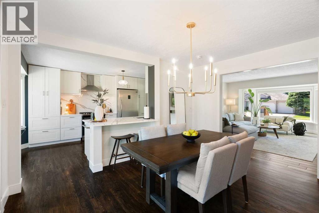 Rich hardwood floors anchor the spacious dining room, offering a sneak peek into the gorgeous kitchen