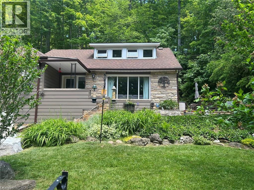 Stone veneer and horizontal siding exterior with a dormer featuring multiple windows