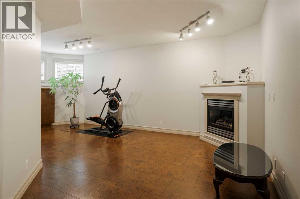 Basement living room with cohesive built in cabinets and cork tile flooring, gas fireplace