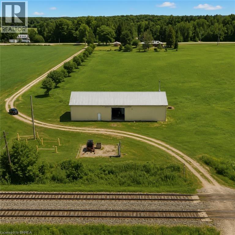 Large agricultural building featuring a metal roof and open bay door