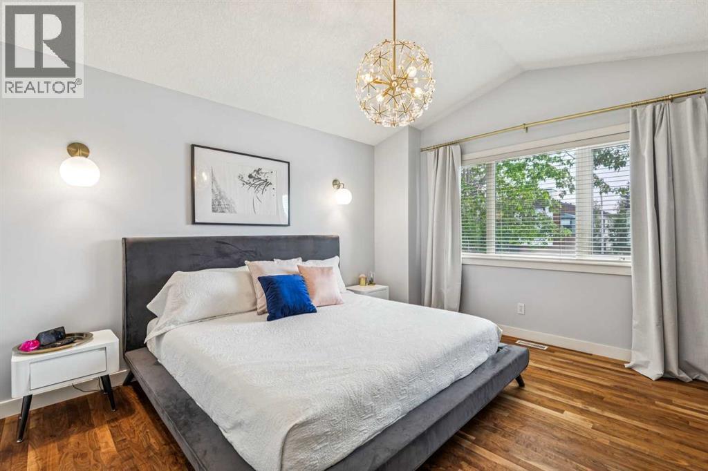 Primary Bedroom enjoys vaulted ceilings & large windows