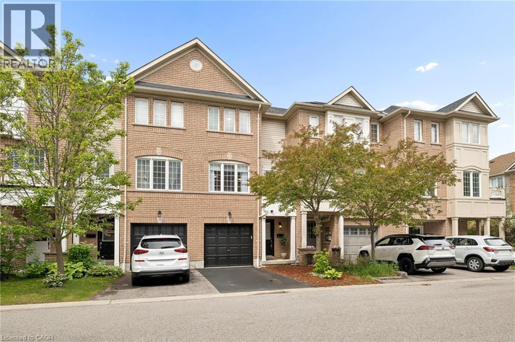 Multi-level townhome featuring a brick facade and multiple bay windows