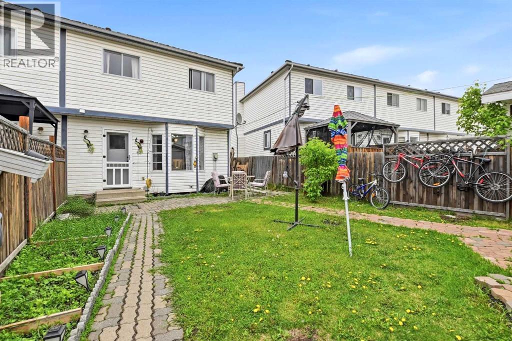 Outside, enjoy the fully fenced yard complete with garden beds, a stone patio, a custom storage shed, and a rear parking pad for a couple of vehicles