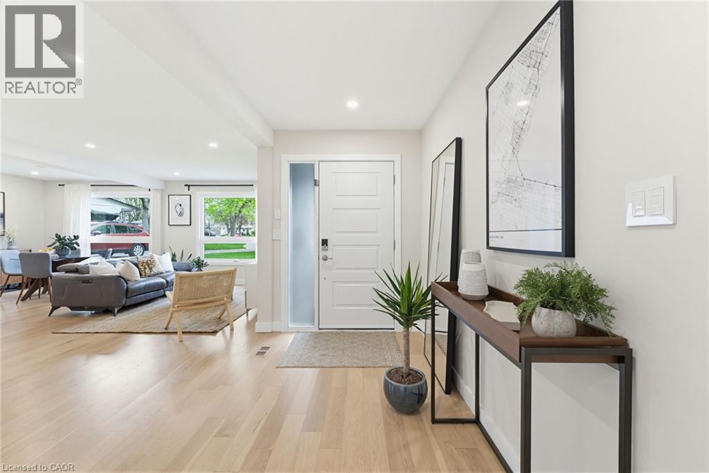 Light engineered hardwood flooring extending through an open-concept living area