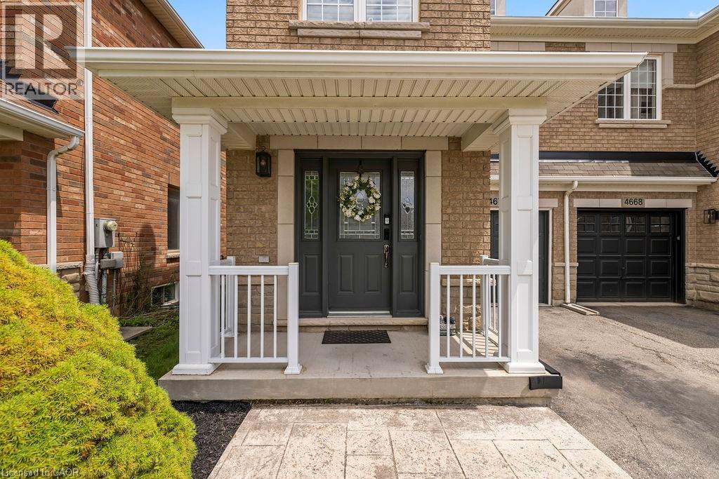 Covered front porch with white columns and railings, featuring a dark gray door with decorative glass inserts