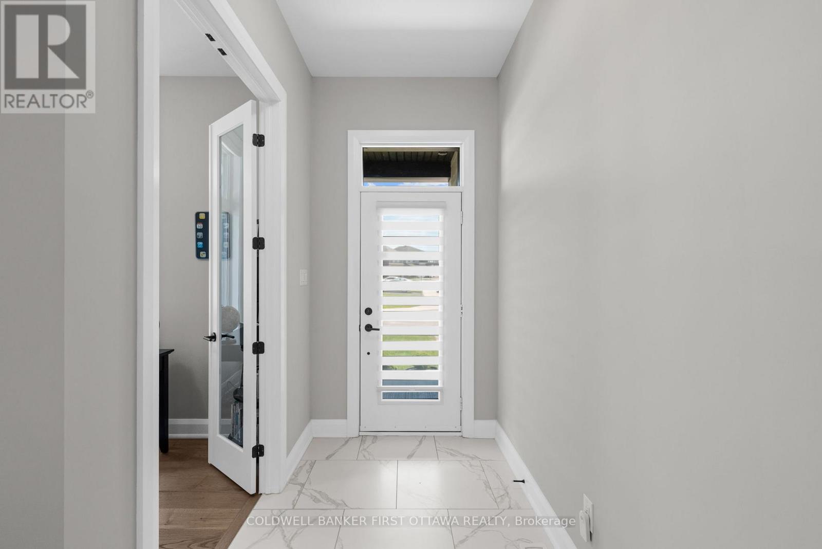 Welcoming front foyer w marble style tile.