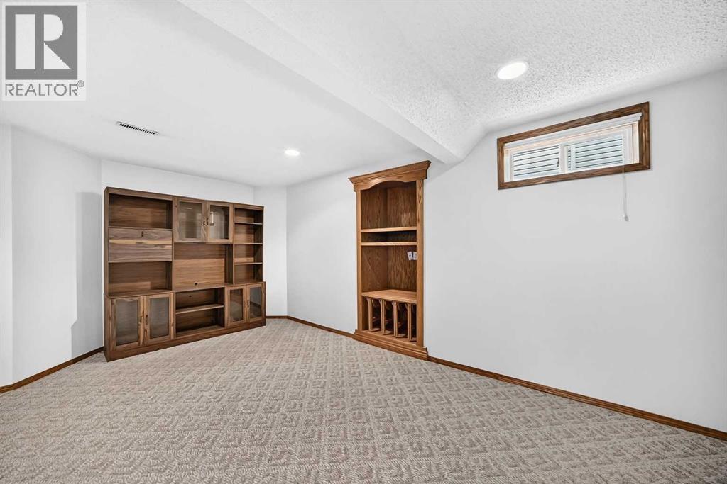 Custom oak built-in unit on the right features unique pull-out stools. A couple of those stools will be pulled out for your viewing. The left-wall entertainment unit is included with the sale